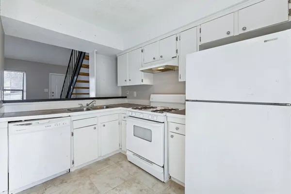 a kitchen with white cabinets and white appliances