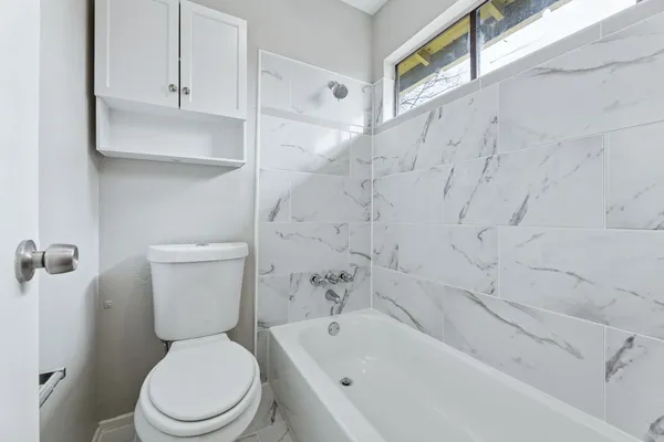 a white toilet sitting next to a bath tub