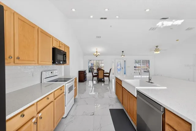 a large white kitchen with lots of counter space and a sink
