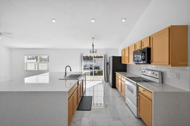 a kitchen with stainless steel appliances granite countertop a sink stove and refrigerator