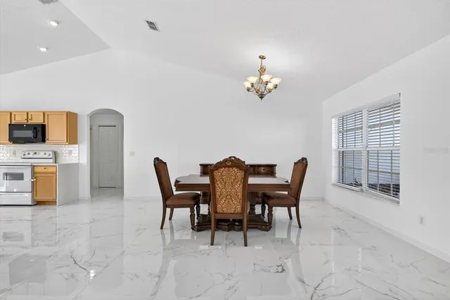 a view of a dining room with furniture and chandelier
