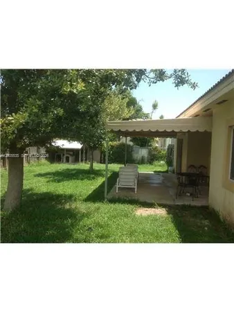 a view of backyard with outdoor seating and green space