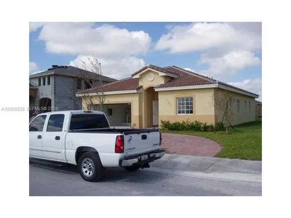 a white car parked in front of a house