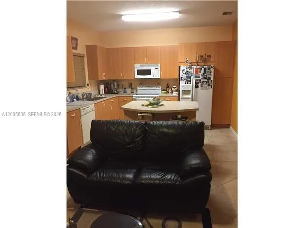 a view of a dining room with furniture and a kitchen