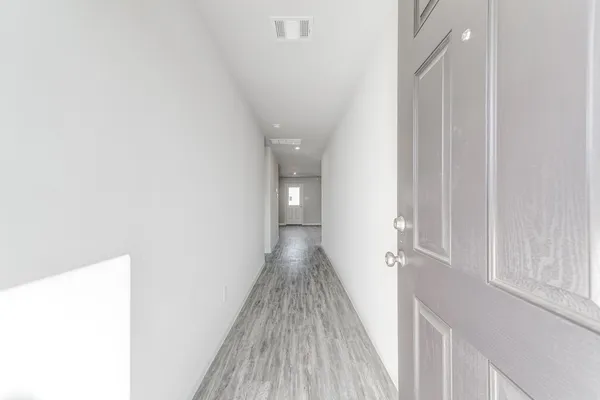 a view of a hallway with wooden floor