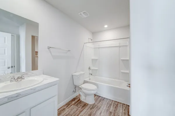 a bathroom with a granite countertop sink toilet a mirror and shower