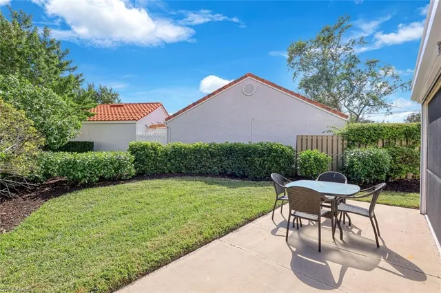 a patio with a table and chairs and potted plants