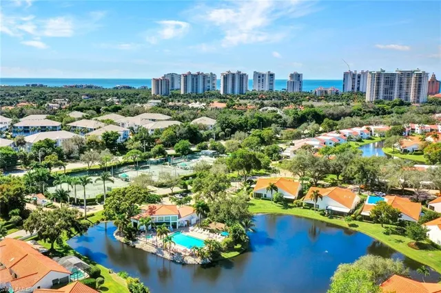 an aerial view of residential houses with outdoor space and lake view