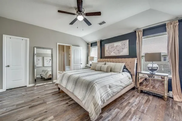 a bedroom with a large bed and a chandelier