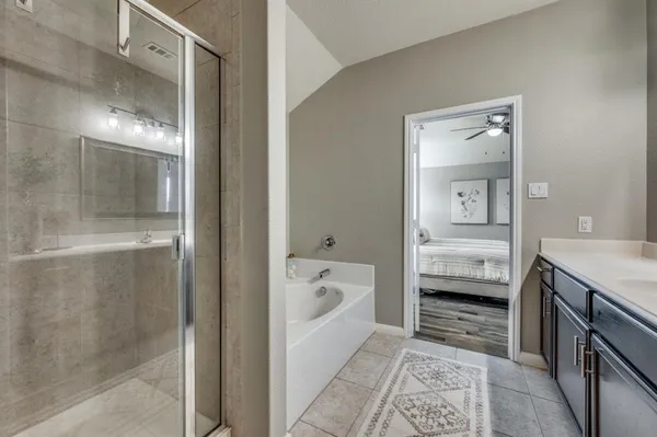 a en suite spacious bathroom with a tub sink and mirror
