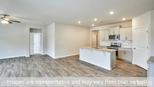 a kitchen with granite countertop a stove top oven and cabinets