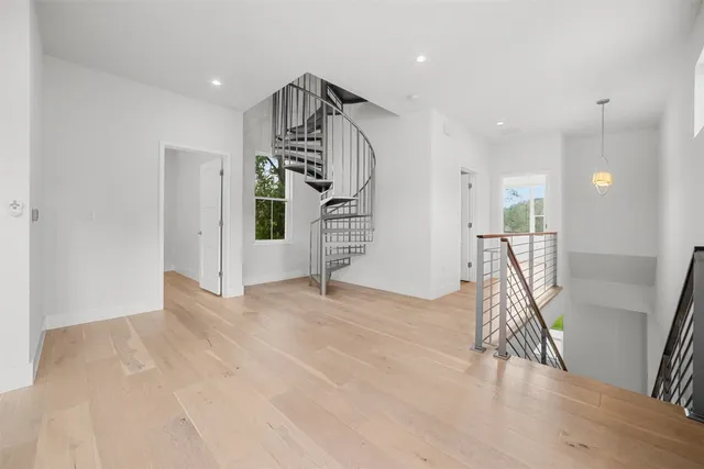 a view of empty room with wooden floor