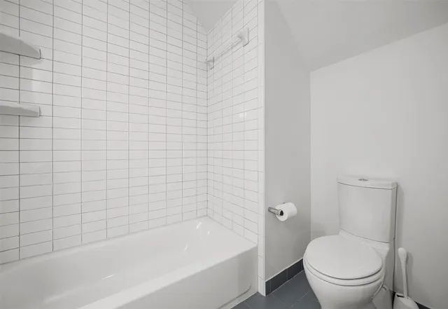 a bathroom with a granite countertop toilet a sink and bathtub