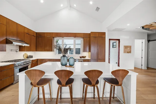 a kitchen with cabinets and chairs