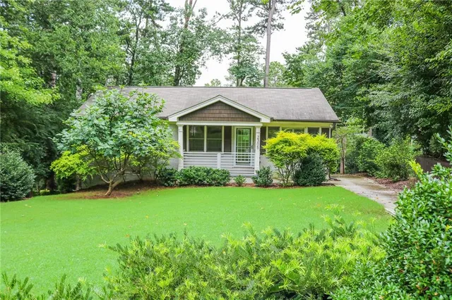 a aerial view of a house next to a big yard and large trees