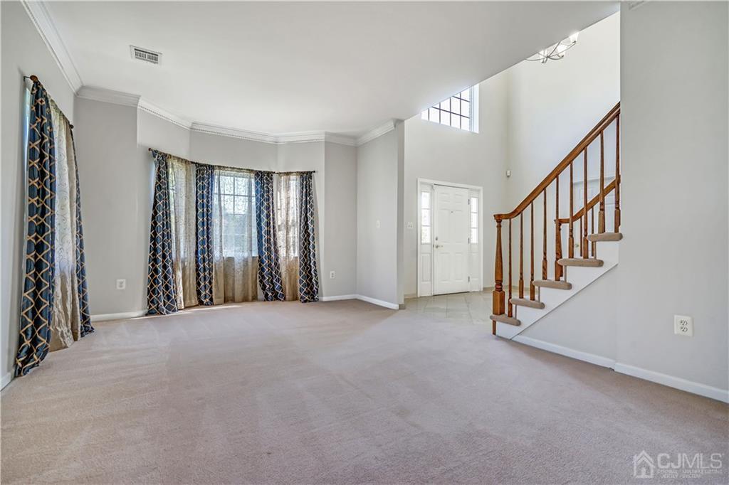 12 Mapleton Road Old Bridge, NJ 08857 - Photo 6 of 22 a view of an empty room with stairs and a window