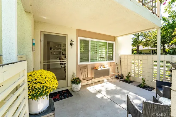a view of a patio with couches and table and chairs and potted plants