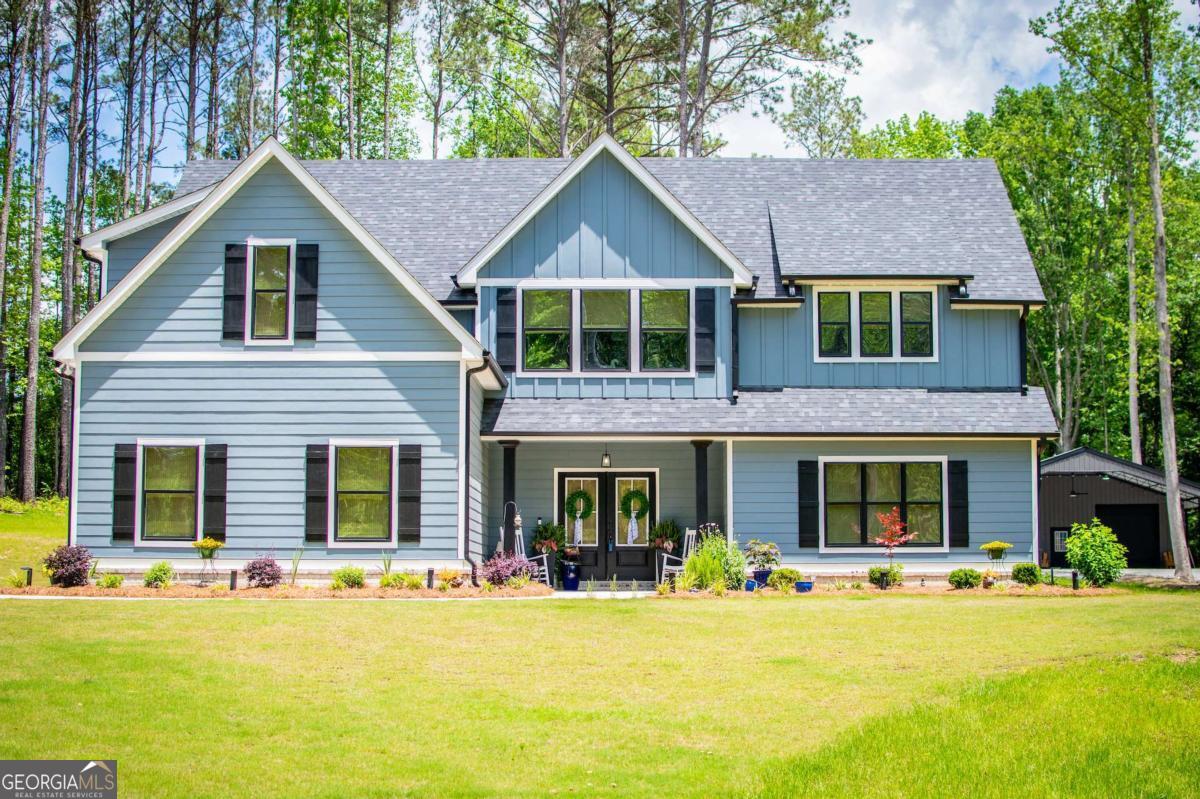 a front view of a house with swimming pool and porch with furniture