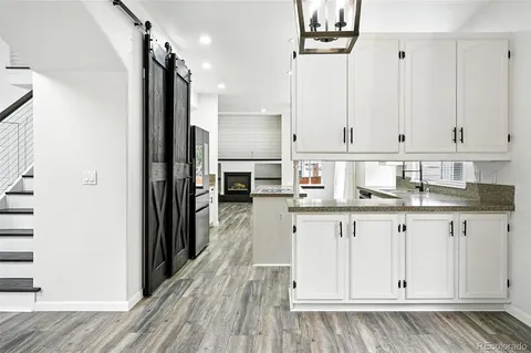 a kitchen with stainless steel appliances granite countertop a refrigerator and white cabinets