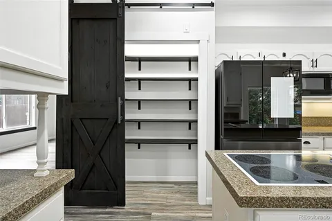 a kitchen with granite countertop a refrigerator and a sink