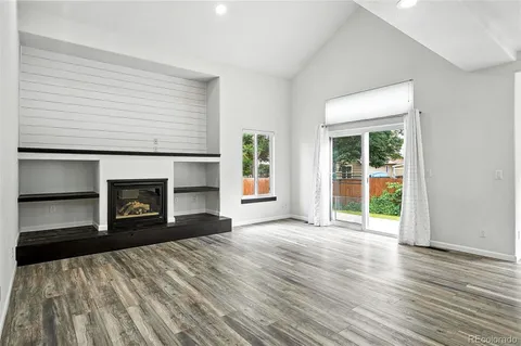 an empty room with windows and a fireplace