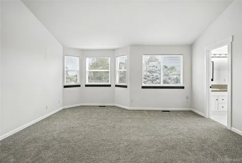 an empty room with windows and closet