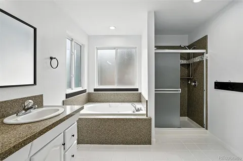 a bathroom with a tub sink and mirror