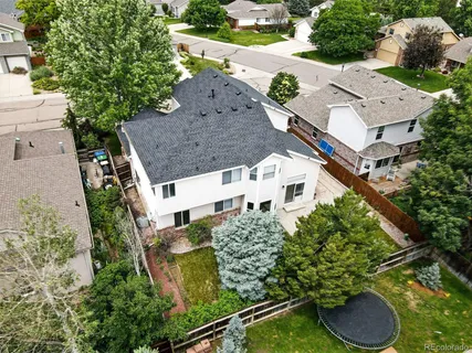 an aerial view of a house with a yard and large tree