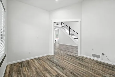 a view of a room with wooden floor and white walls