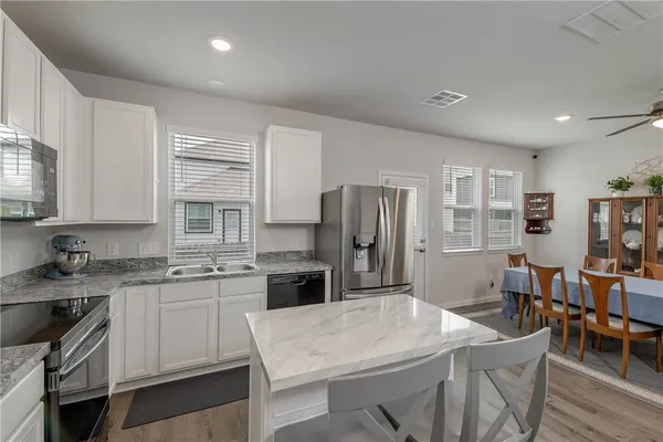 a kitchen with refrigerator cabinets dining table and chairs