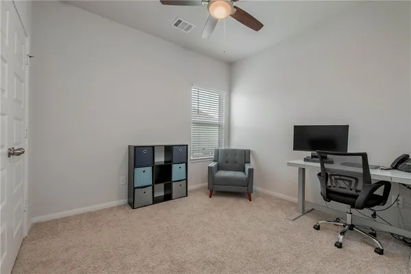 a view of a livingroom with workspace and a window