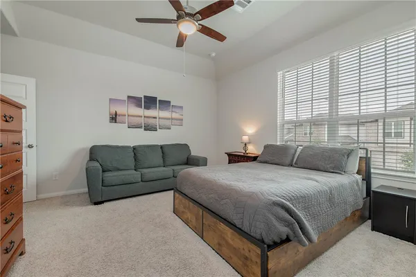 a bedroom with a bed couch and window