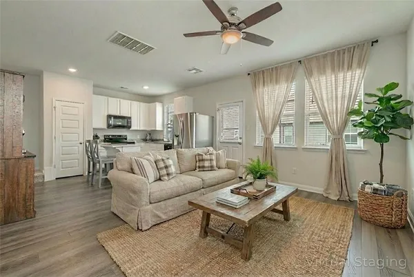 a living room with furniture kitchen view and a window