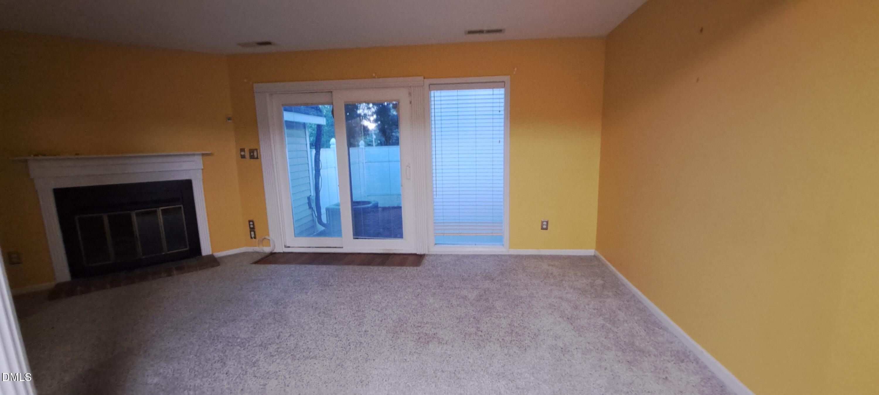 2501 St Christopher Circle Southwest, Unit 6 Wilson, NC 27893 - Photo 2 of 10 a view of an empty room with wooden floor and a fireplace