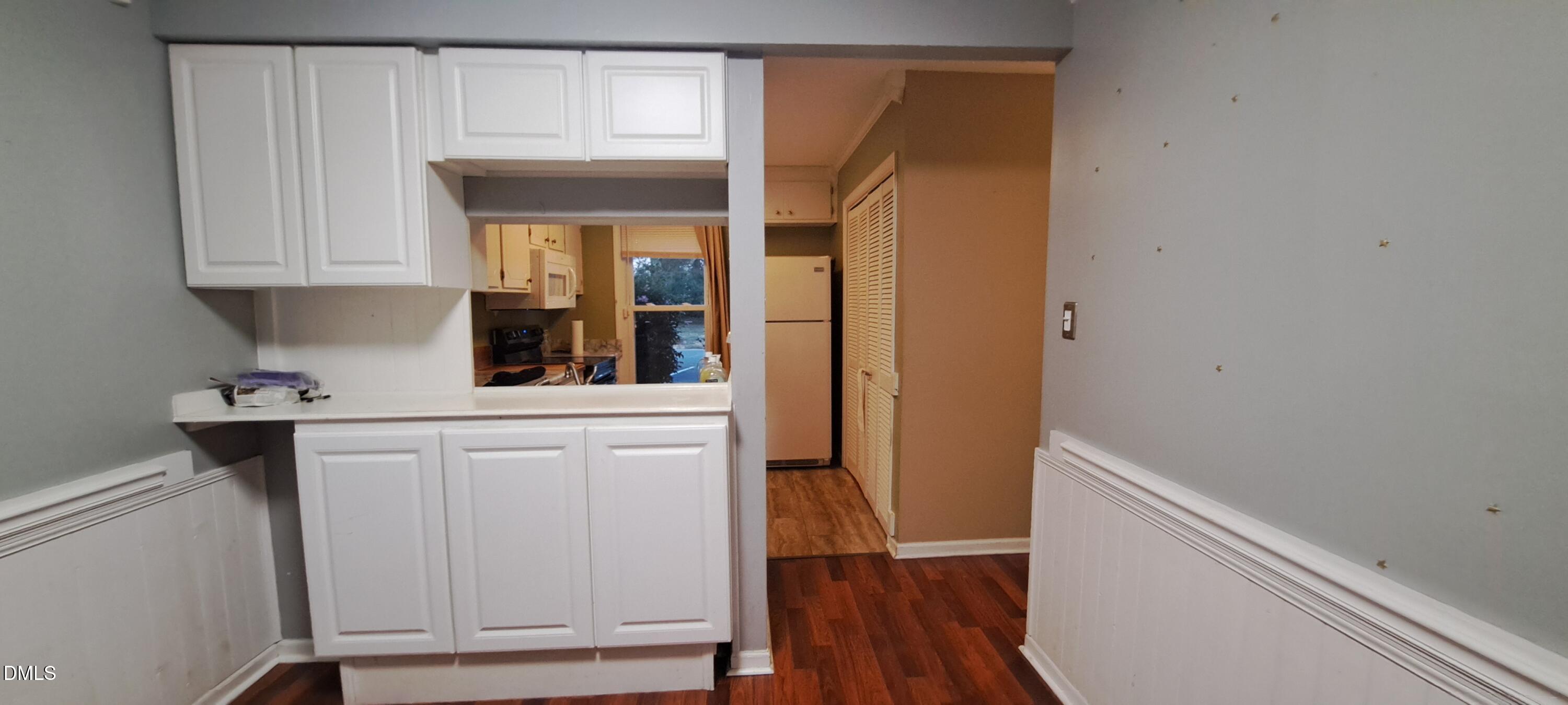 2501 St Christopher Circle Southwest, Unit 6 Wilson, NC 27893 - Photo 4 of 10 a kitchen with white cabinets and a wooden floor