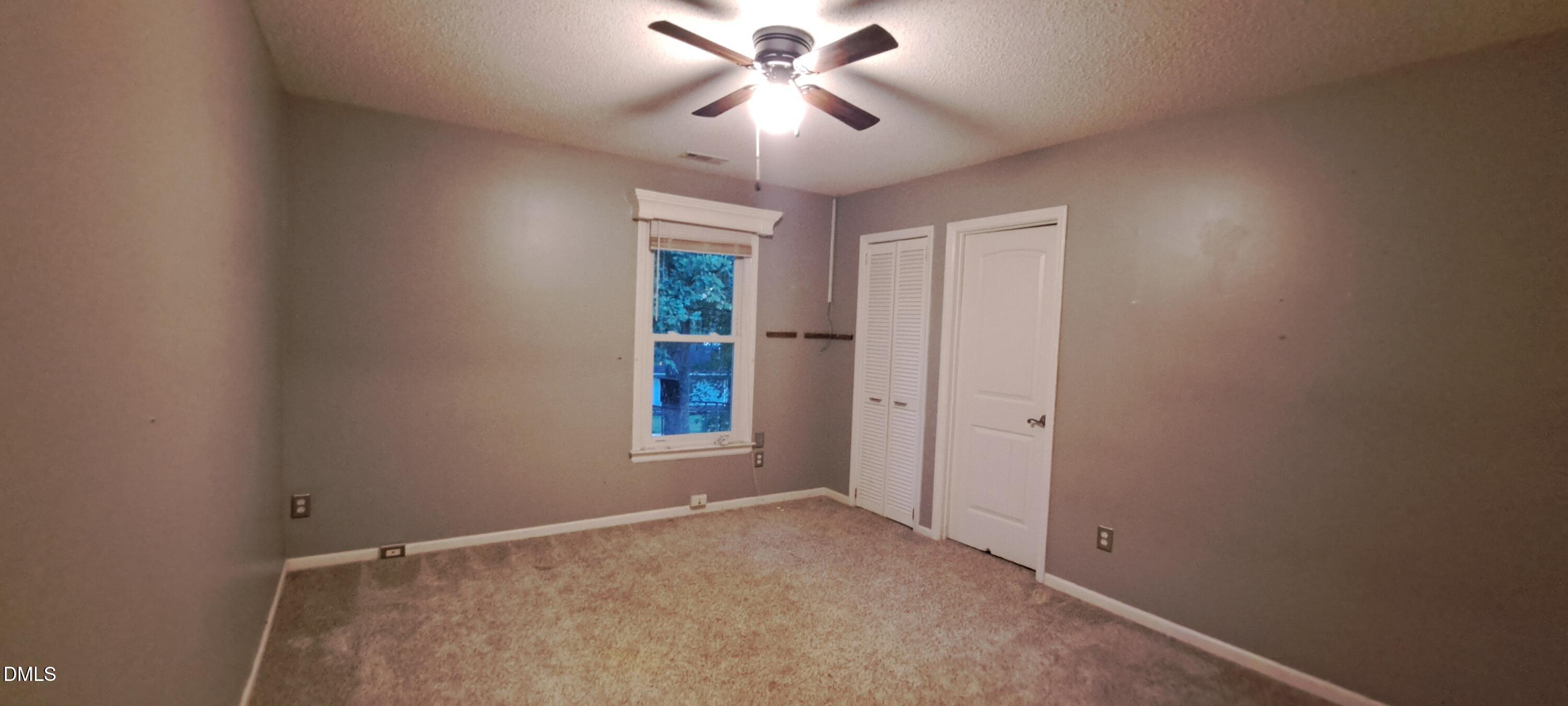 2501 St Christopher Circle Southwest, Unit 6 Wilson, NC 27893 - Photo 5 of 10 a view of empty room with window and chandelier fan