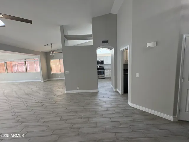 a view of a hallway with wooden floor and a living room