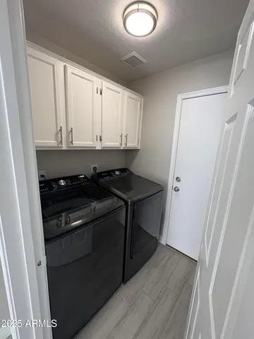 a view of a refrigerator a stove and cabinets