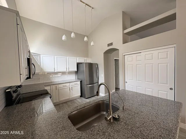 a kitchen with a refrigerator a sink and cabinets