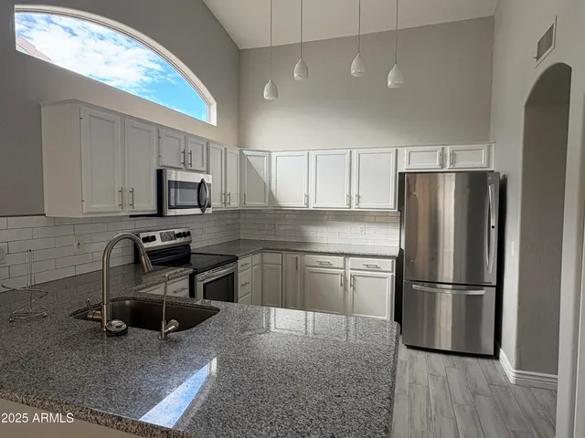 a kitchen with a refrigerator cabinets and wooden floor