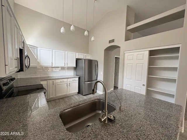 a kitchen with refrigerator and cabinets