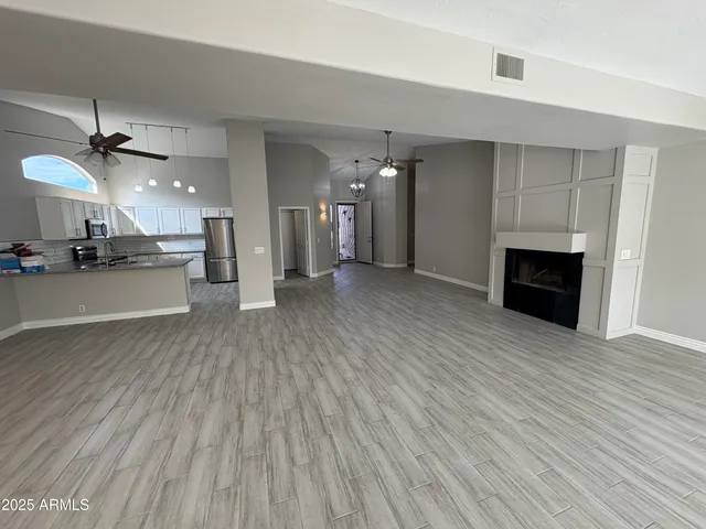 an empty room with wooden floor a fireplace and window
