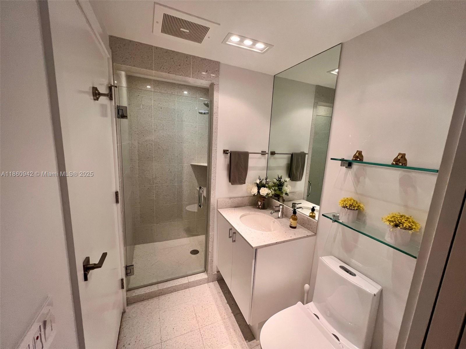 3801 Collins Avenue, Unit 705 Miami Beach, FL 33140 - Photo 13 of 18 a bathroom with a sink a toilet a mirror and shower