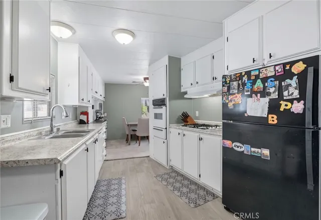 a kitchen with stainless steel appliances granite countertop a sink stove and cabinets