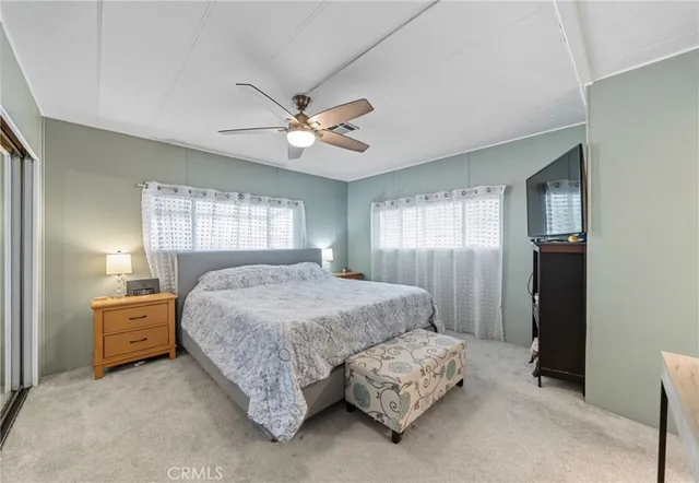 a spacious bedroom with a bed a window and dresser