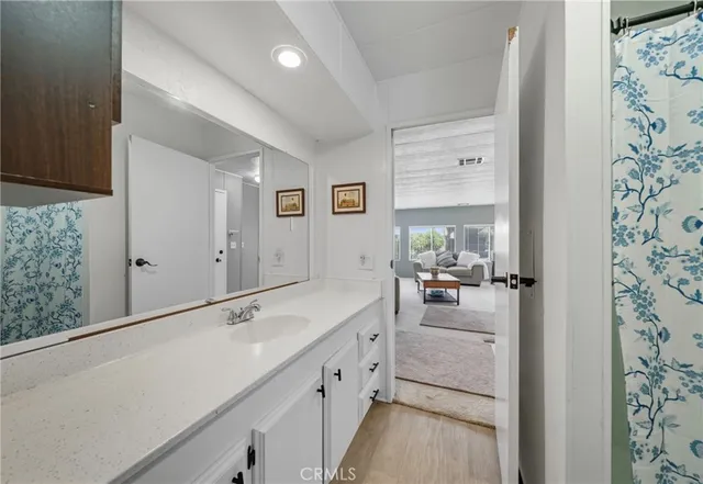 a view of a hallway with bathroom and mirror