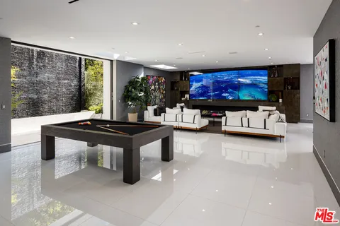 a living room with furniture a flat screen tv and a large window