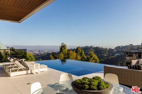 a view of a terrace with furniture and a garden