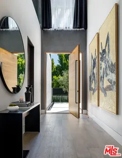 a view of a hallway with wooden floor and a potted plant
