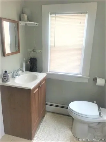 a bathroom with a sink a toilet and window